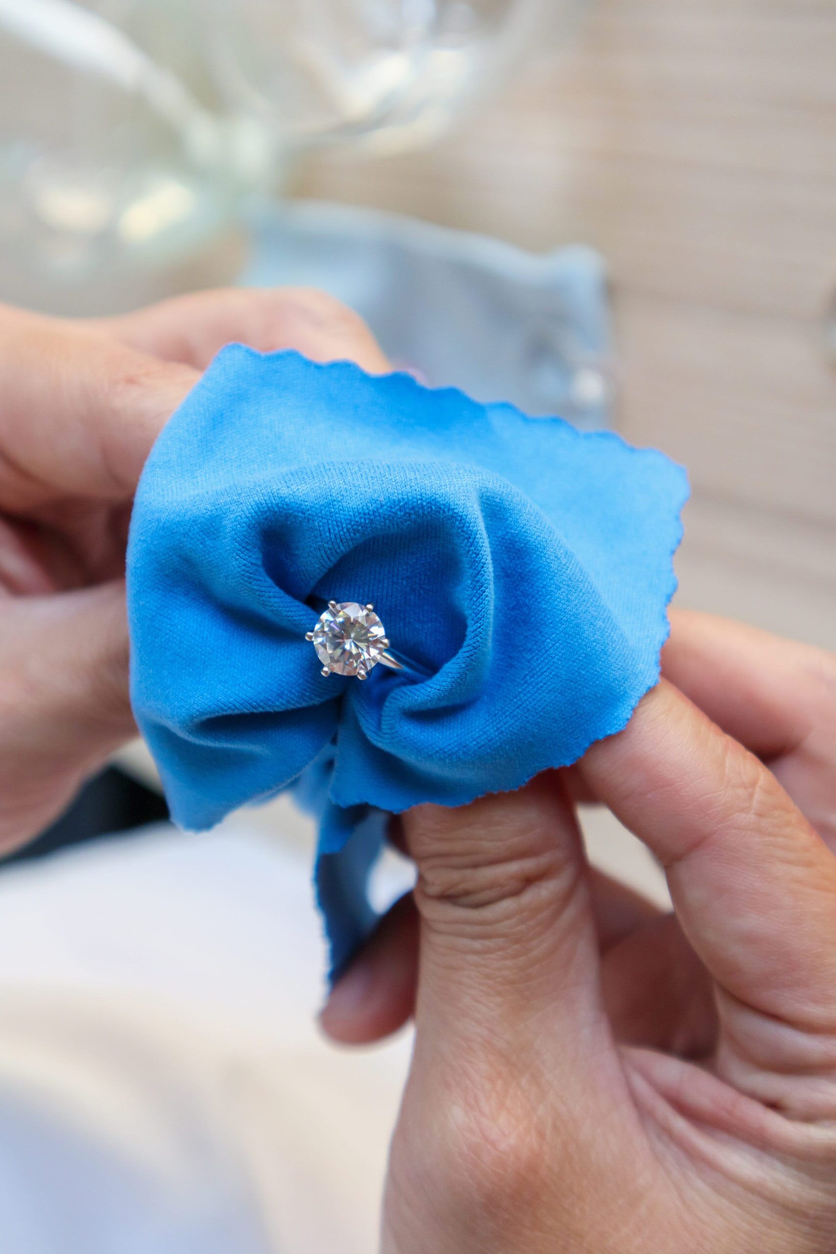 Jeweller hand polishing and cleaning jewelry diamond ring with micro fiber fabric<br />
